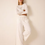 White ribbed cotton knit set including a long-sleeve top and wide-leg pants.