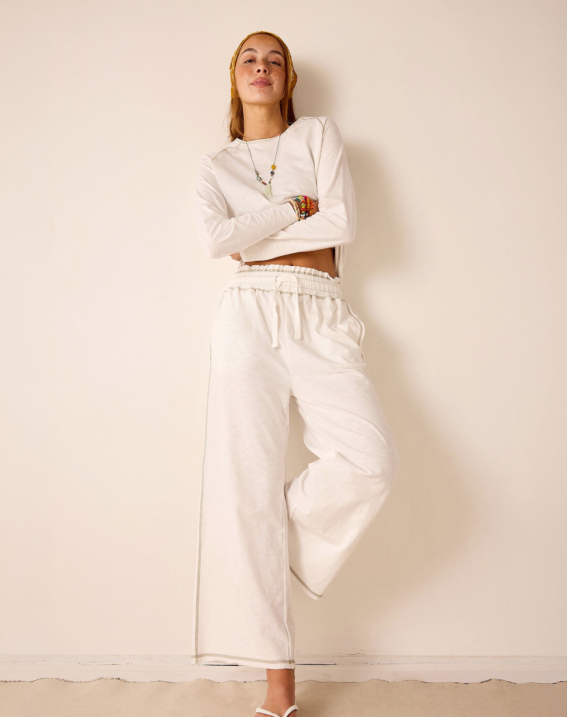 White ribbed cotton knit set including a long-sleeve top and wide-leg pants.