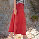 Cayenne terracotta orange linen midi skirt with high waist and wide leg flowy silhouette.