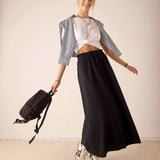 Women's travel-friendly graphite long flowing skirt and white cropped tee paired with a light grey linen shirt.