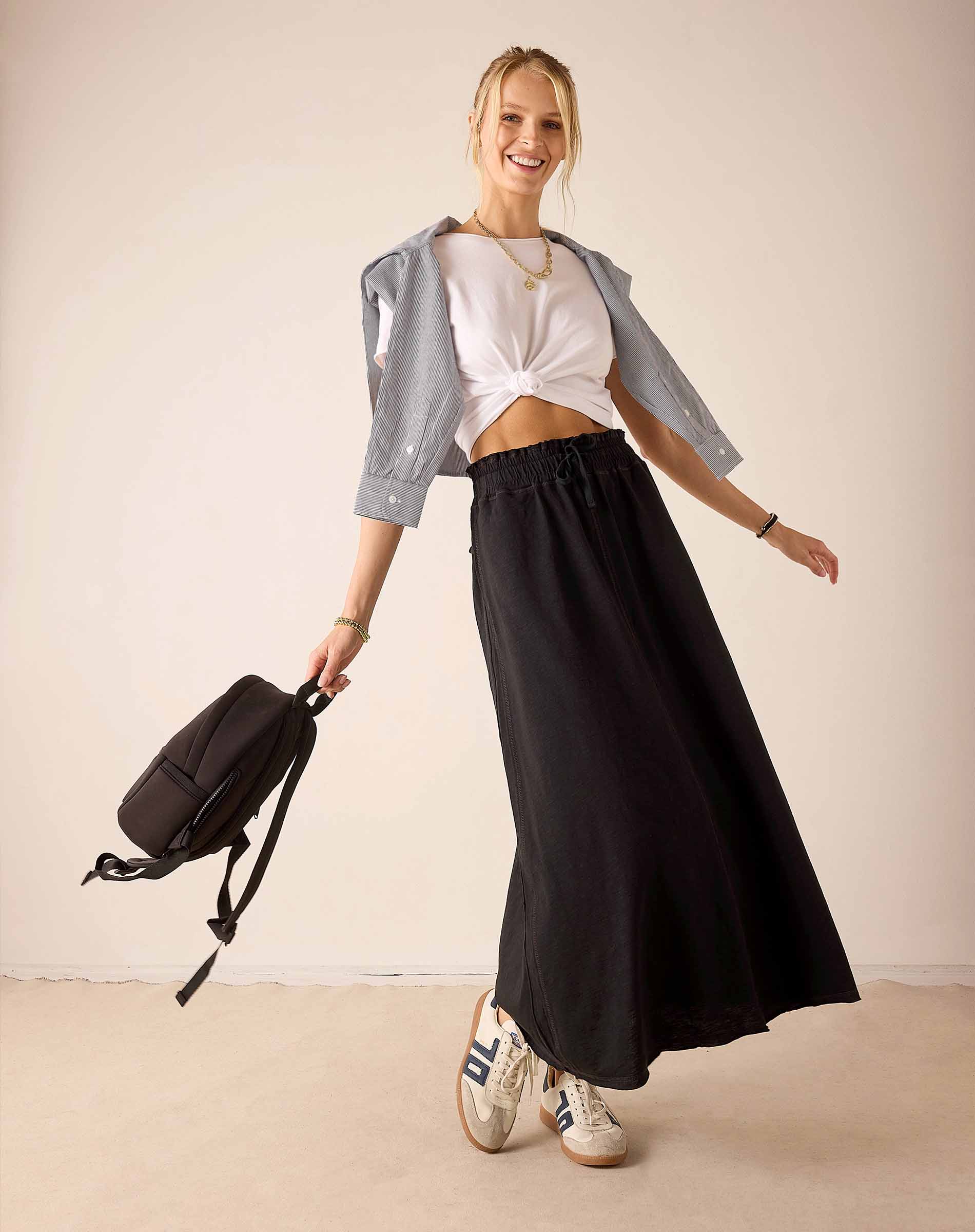 Women's travel-friendly graphite long flowing skirt and white cropped tee paired with a light grey linen shirt.