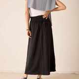 Graphite linen blend maxi skirt with an elasticized waistband and matching grey knit travel wrap draped over a white tee.