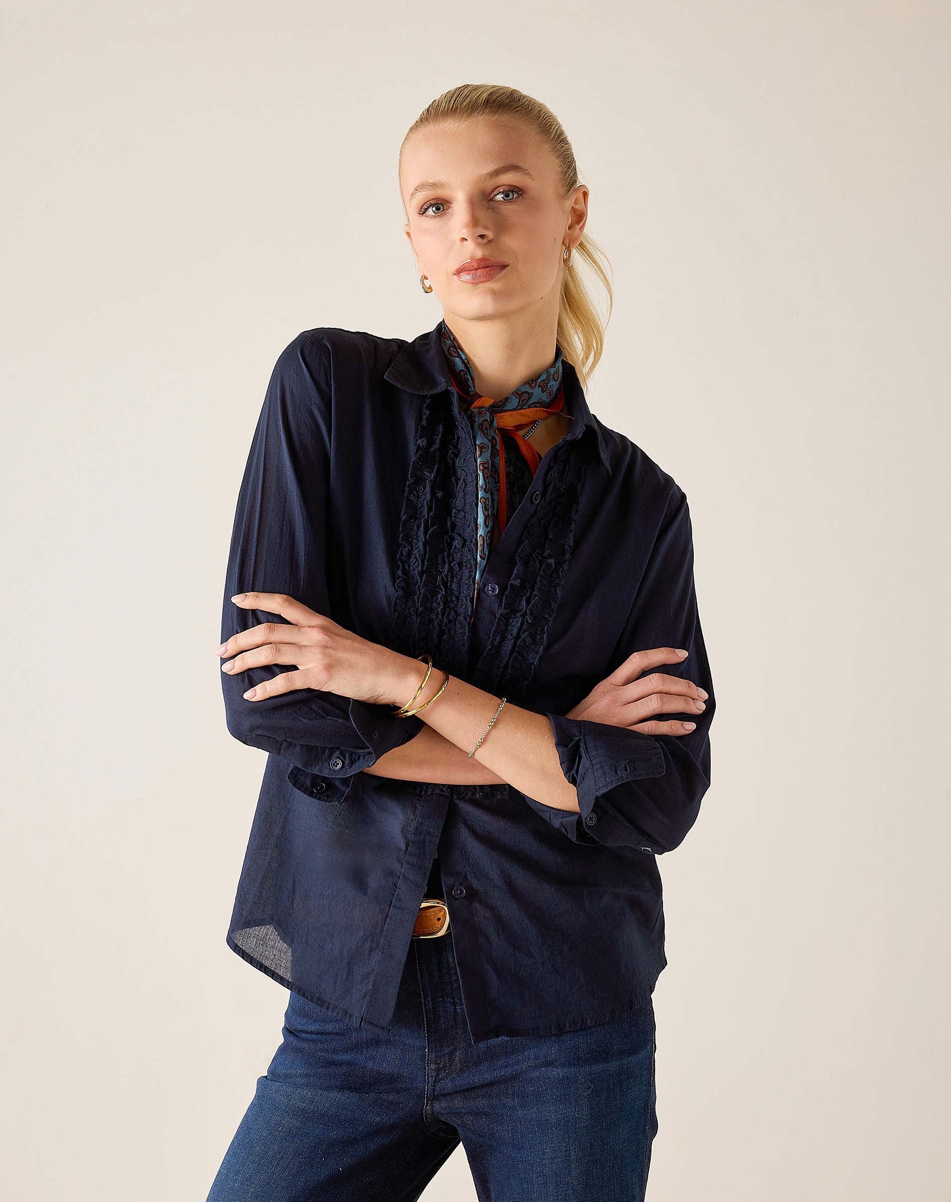 Navy blue ruffled tuxedo shirt with soft drape and elegant pleating details.