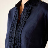 Navy blue ruffled tuxedo shirt with button front and feminine detail.