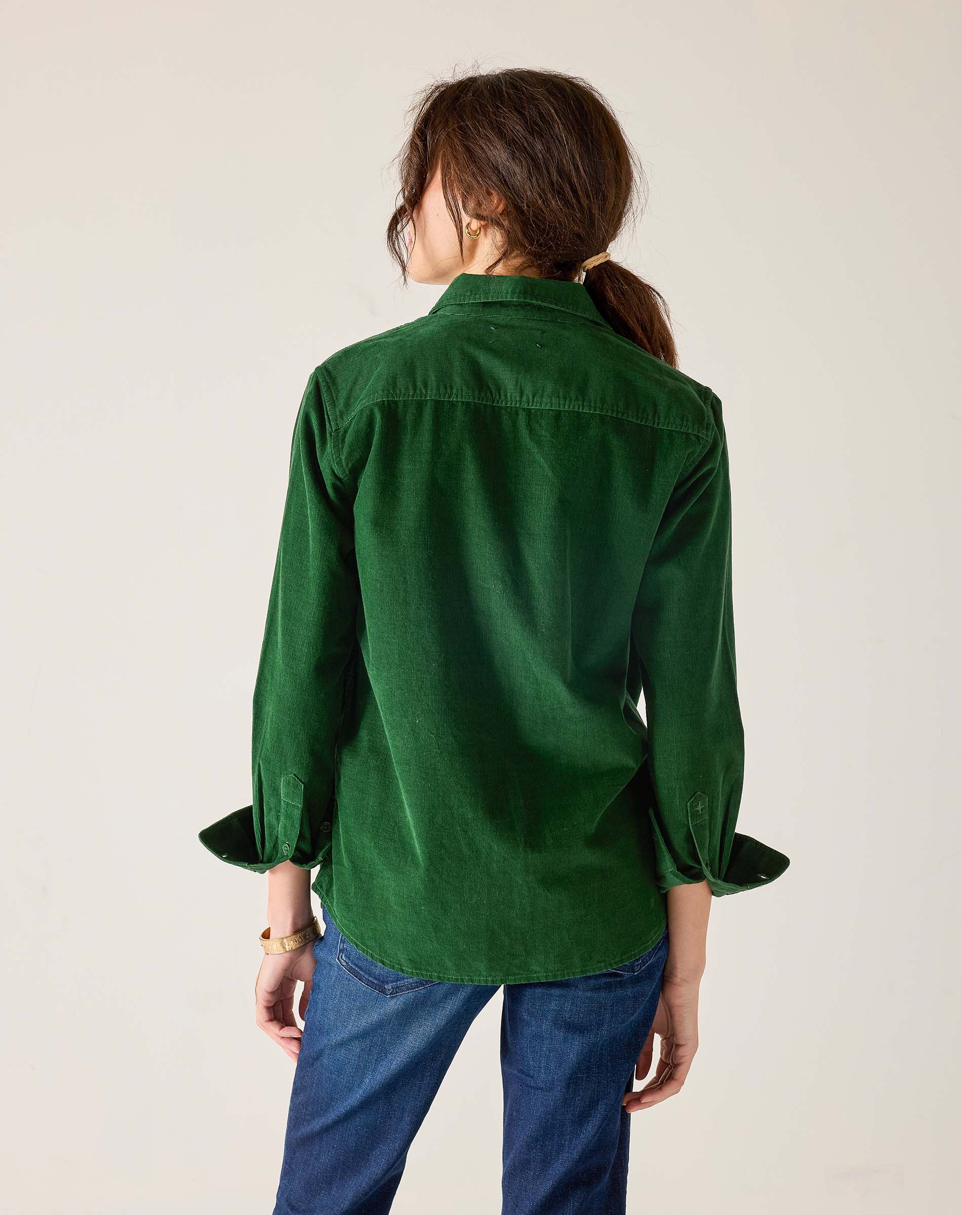 Back view of women's travel-friendly pine green tuxedo ruffle shirt in a soft cotton blend.