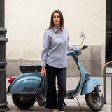 Ladies' travel-ready light blue button-down shirt with intricate white embroidery and ruffled detailing.