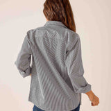 Back view of a soft black pinstripe button-down shirt featuring rolled sleeves and a relaxed fit.