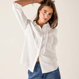 White ruffled tuxedo shirt in a crisp cotton blend featuring feminine ruffle details and button front.
