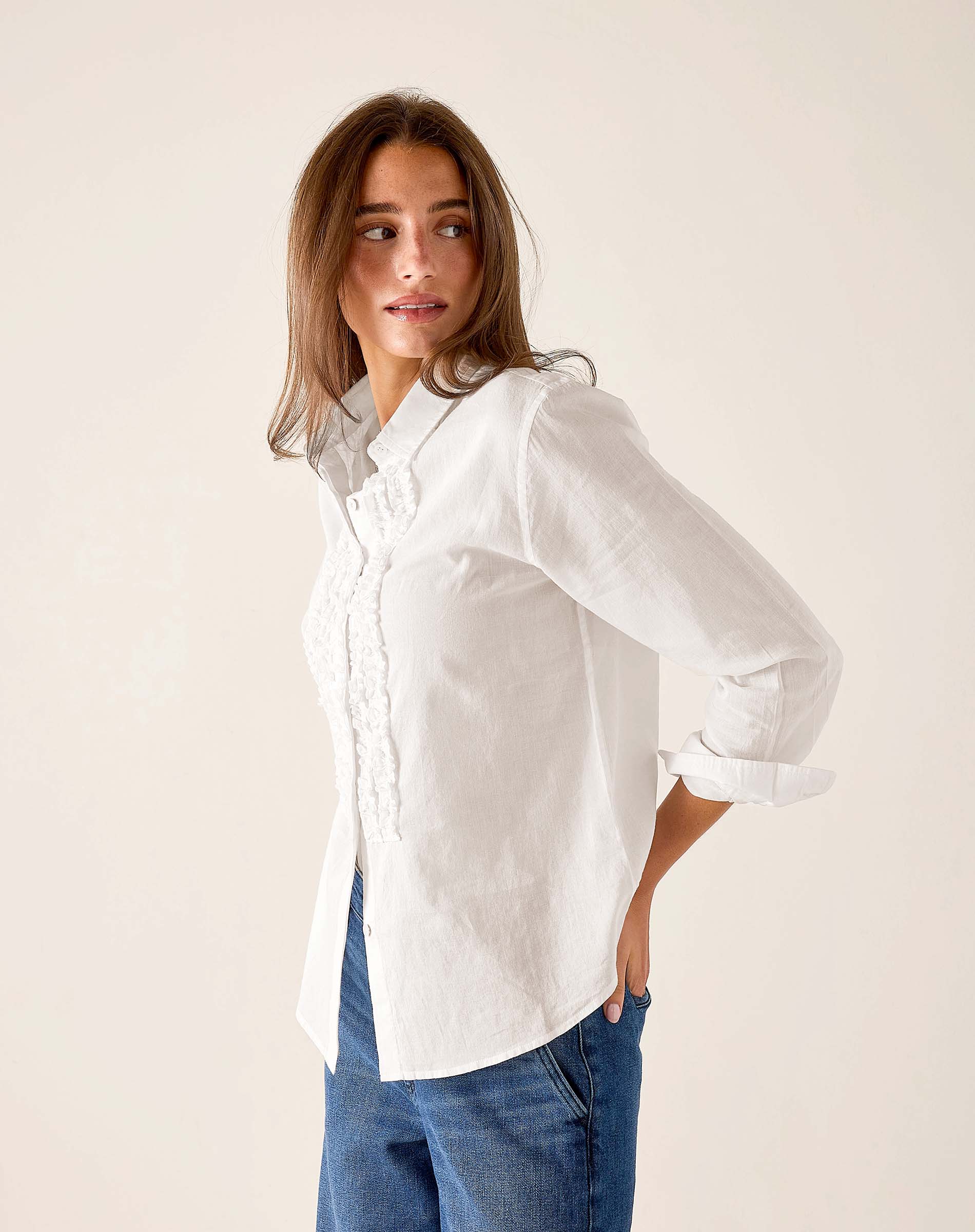 White oversized linen tuxedo ruffle shirt with buttons and pleated front detail.