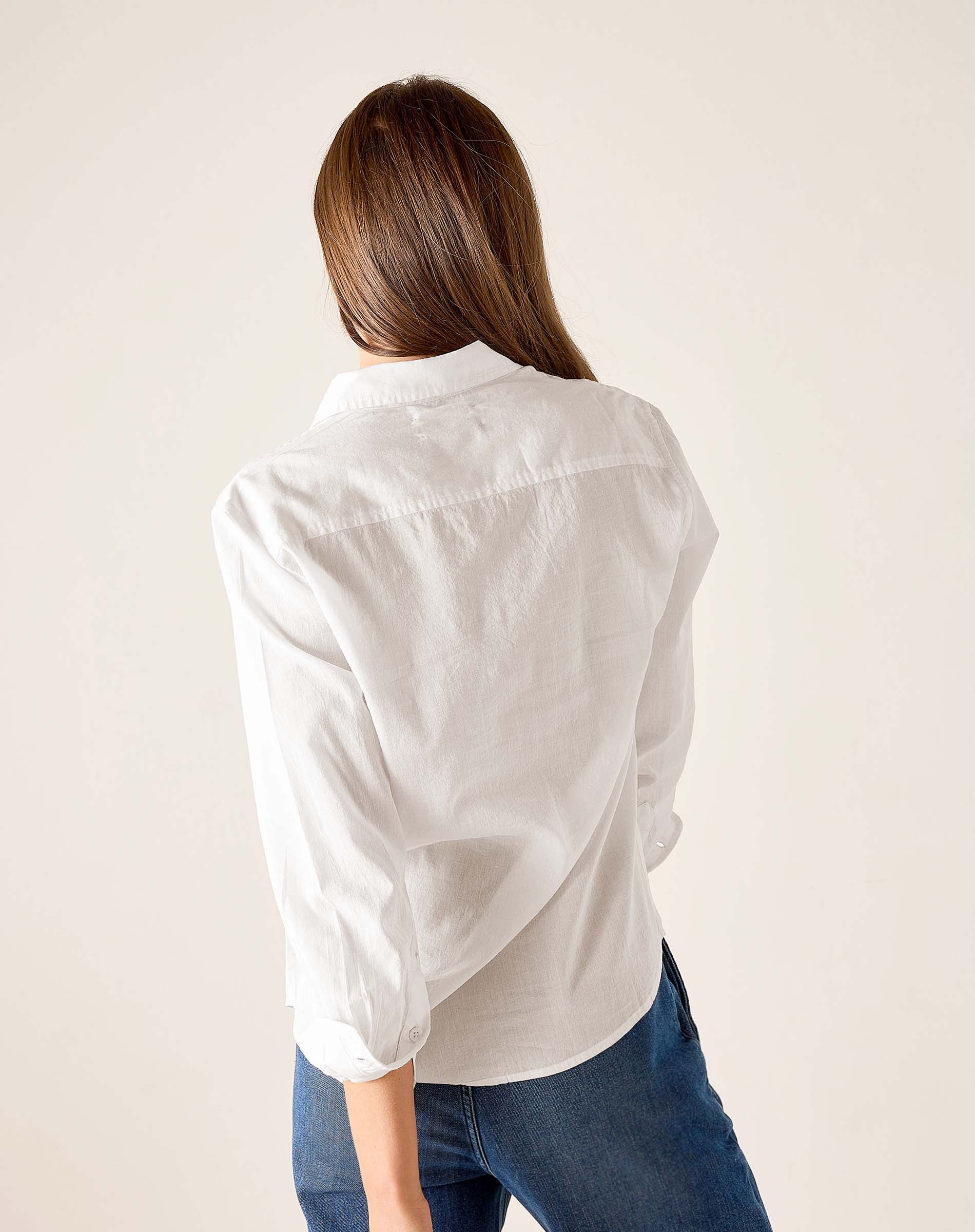 Back view of white tuxedo ruffle shirt for women's travel-friendly wear