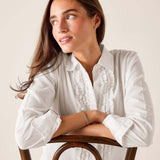 White ruffled tuxedo shirt with a buttoned front and rolled sleeves.