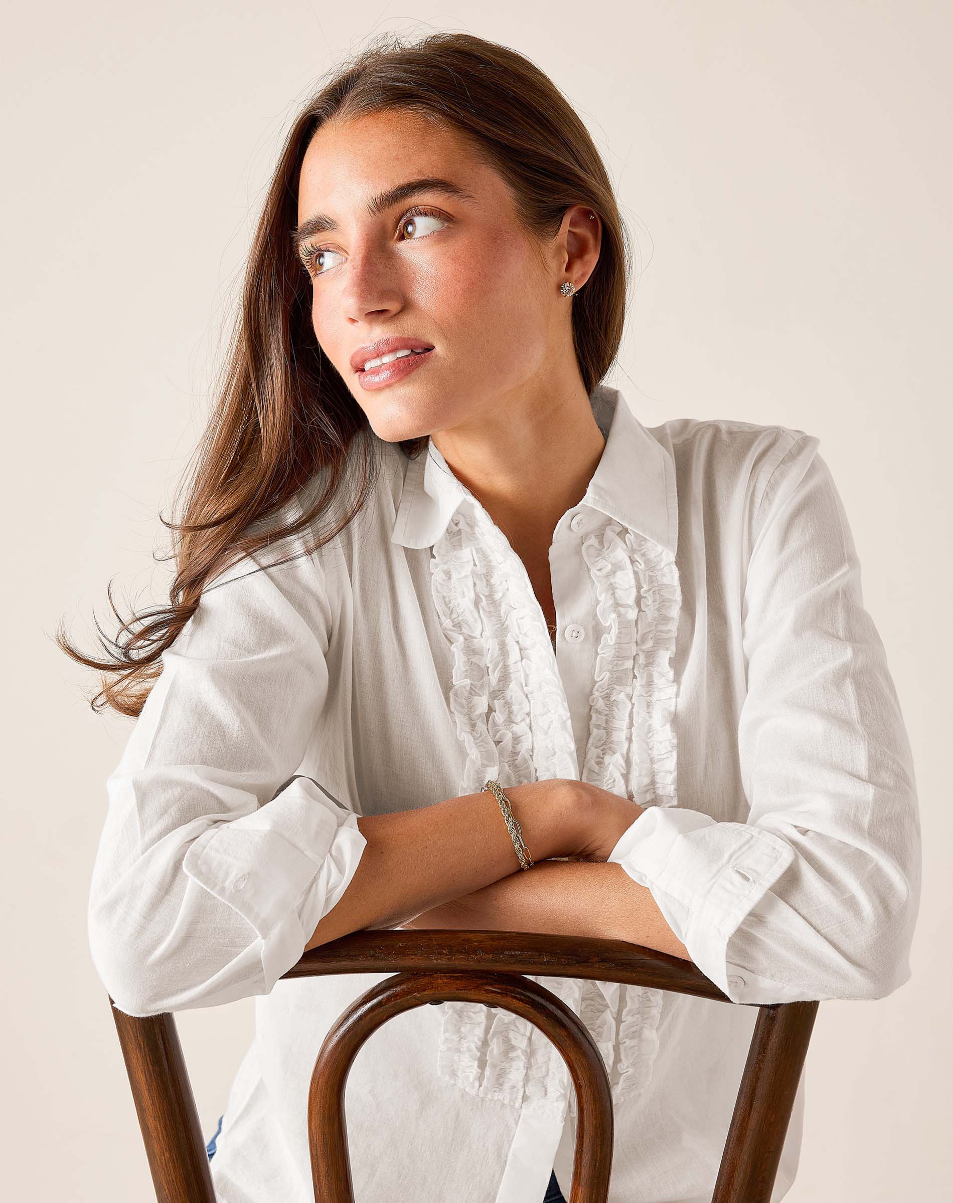 White ruffled tuxedo shirt with a buttoned front and rolled sleeves.