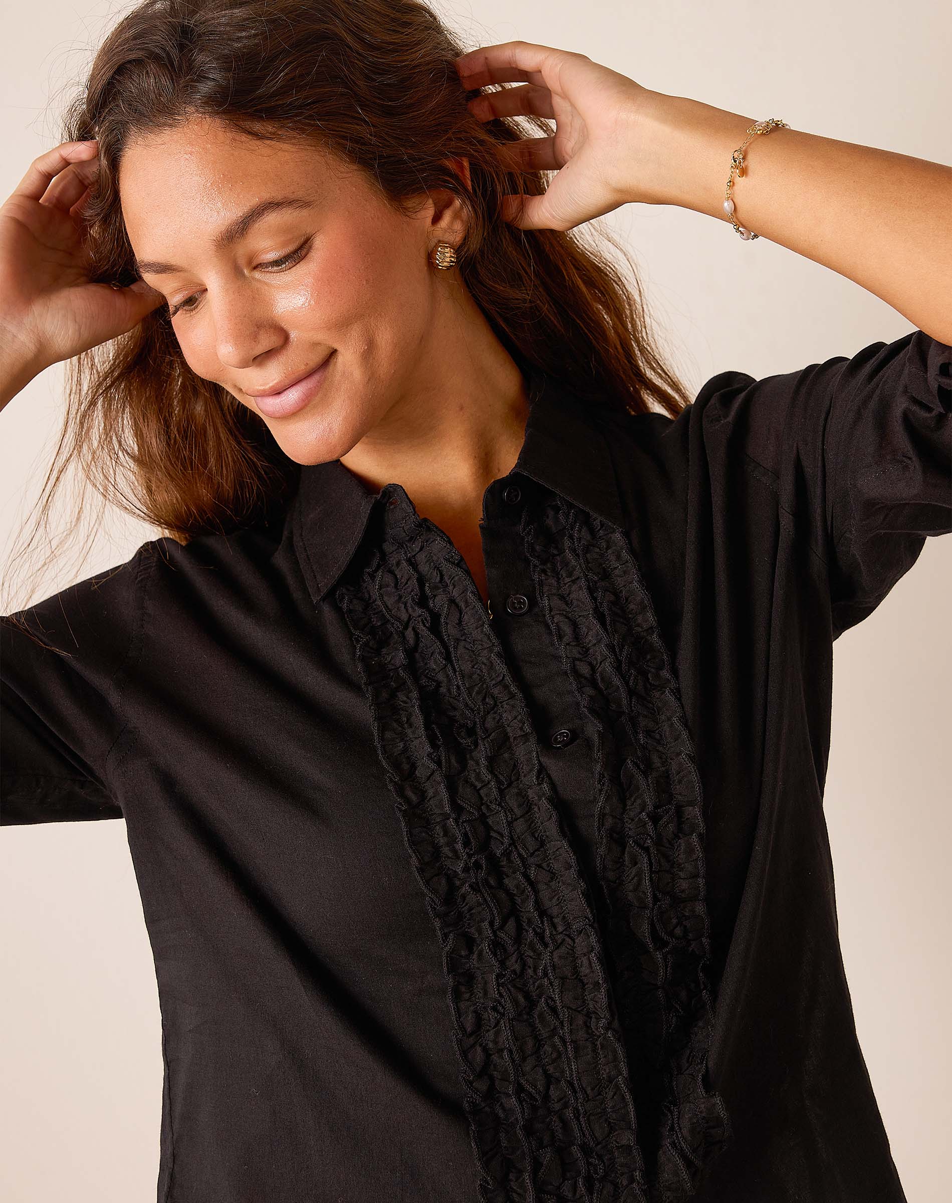 Women's travel-friendly black ruffled tuxedo top with button front and textured detail.