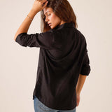 Black relaxed fit silk blend tuxedo ruffle top seen from the side profile.