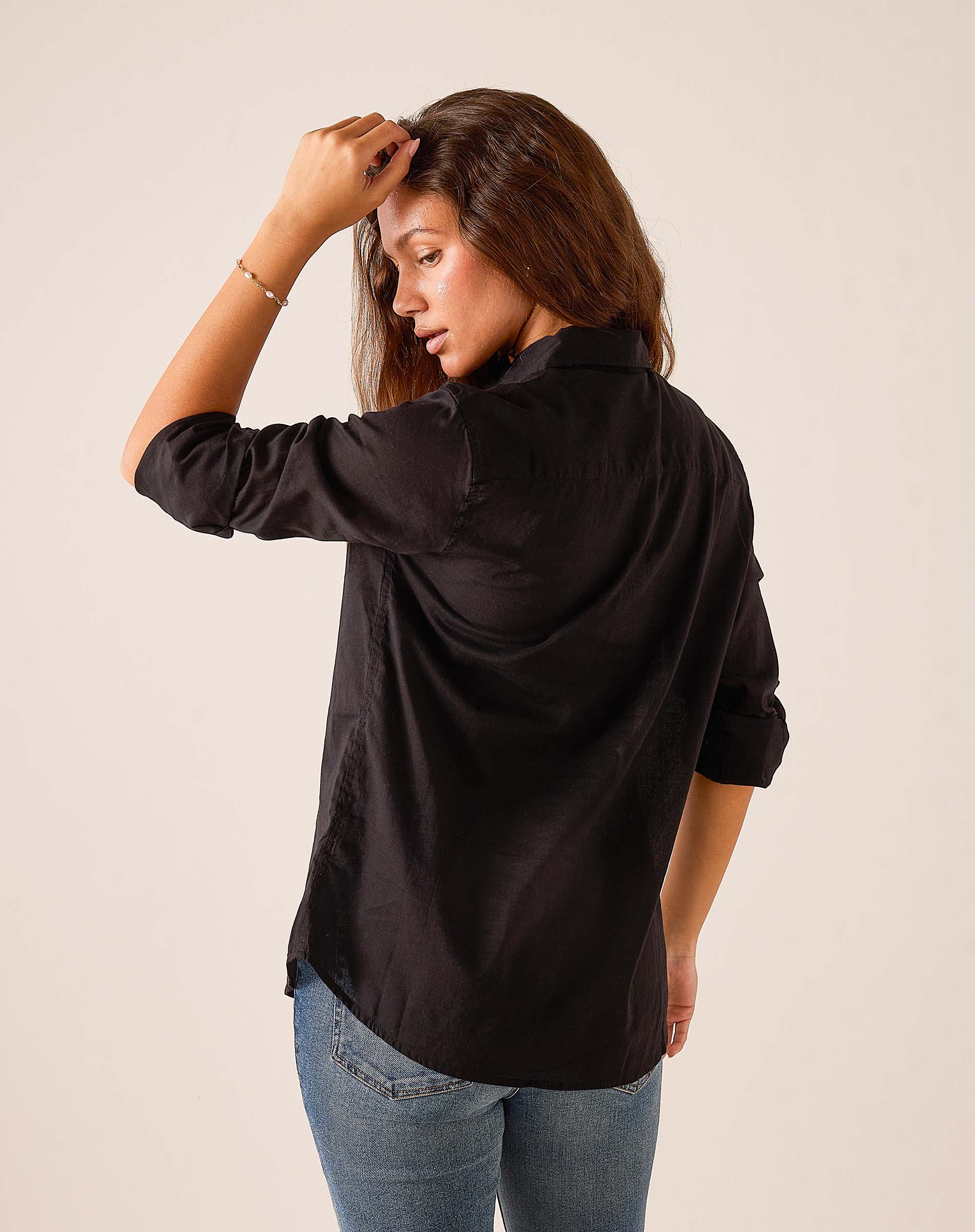 Black relaxed fit silk blend tuxedo ruffle top seen from the side profile.