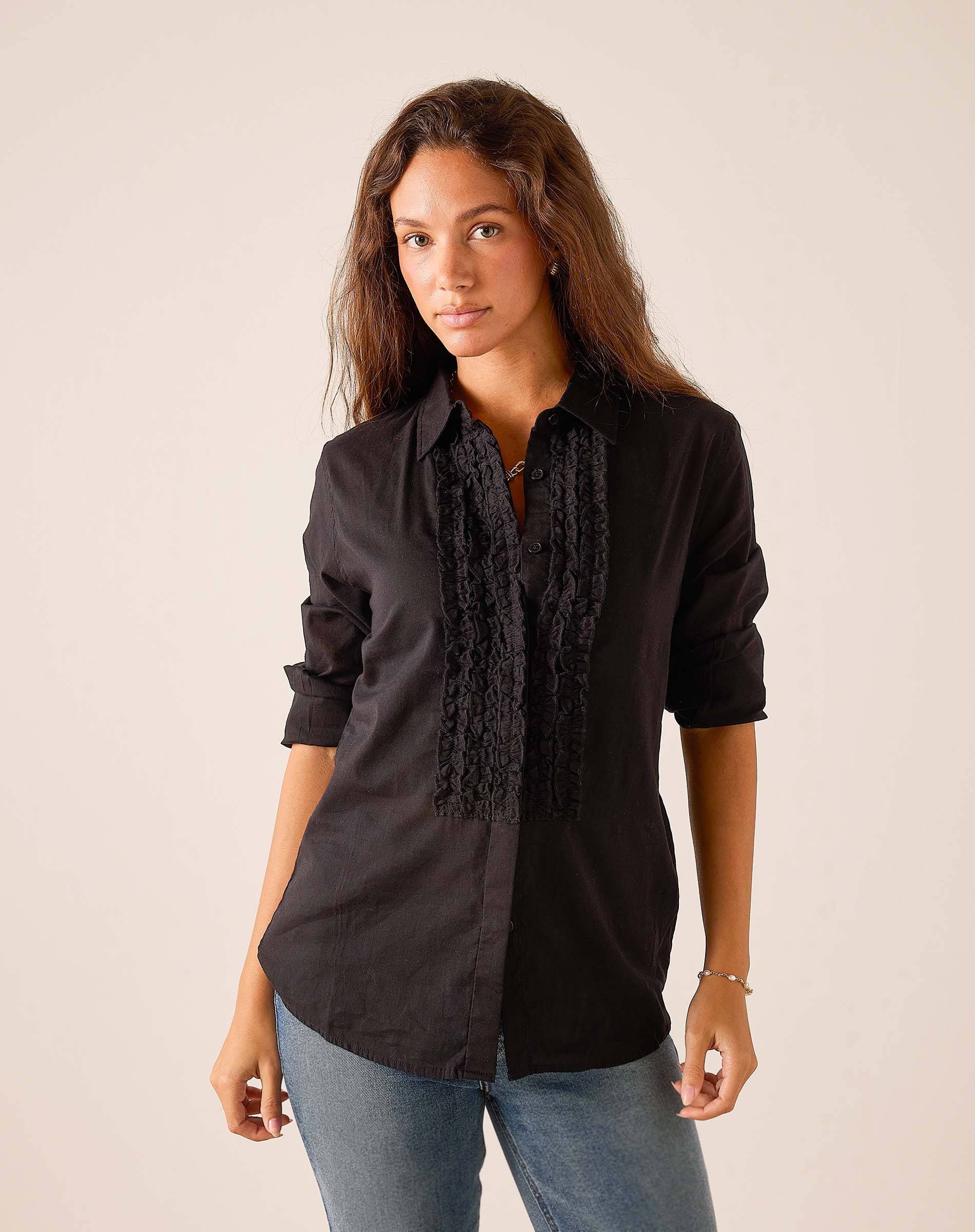 Black ruffled tuxedo top with button front and vertical lace detailing.