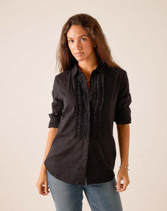Black ruffled tuxedo top with button front and vertical lace detailing.