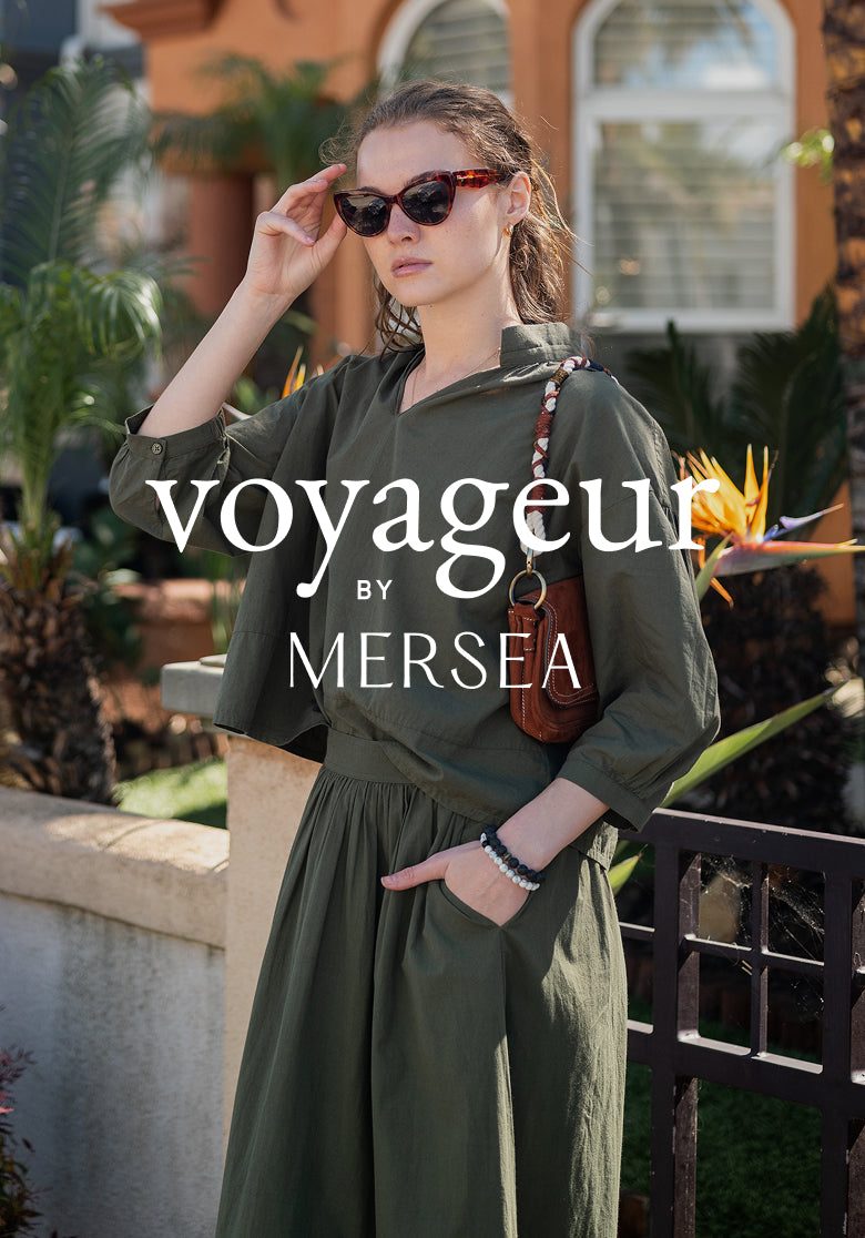 Ladies' travel-ready olive green button-down shirt and matching wide-leg trousers. Text: voyageur BY MERSEA