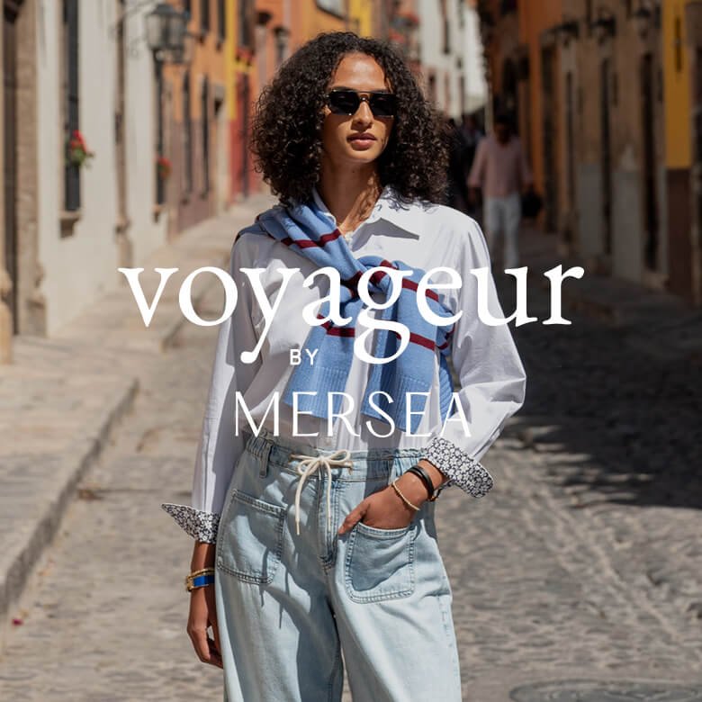 Woman walking down a street wearing sunglasses and a scarf with 'voyageur by MERSEAF' text overlay.