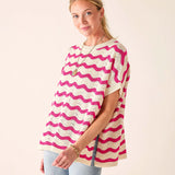 Woman wearing a pink and white patterned top against a plain background
