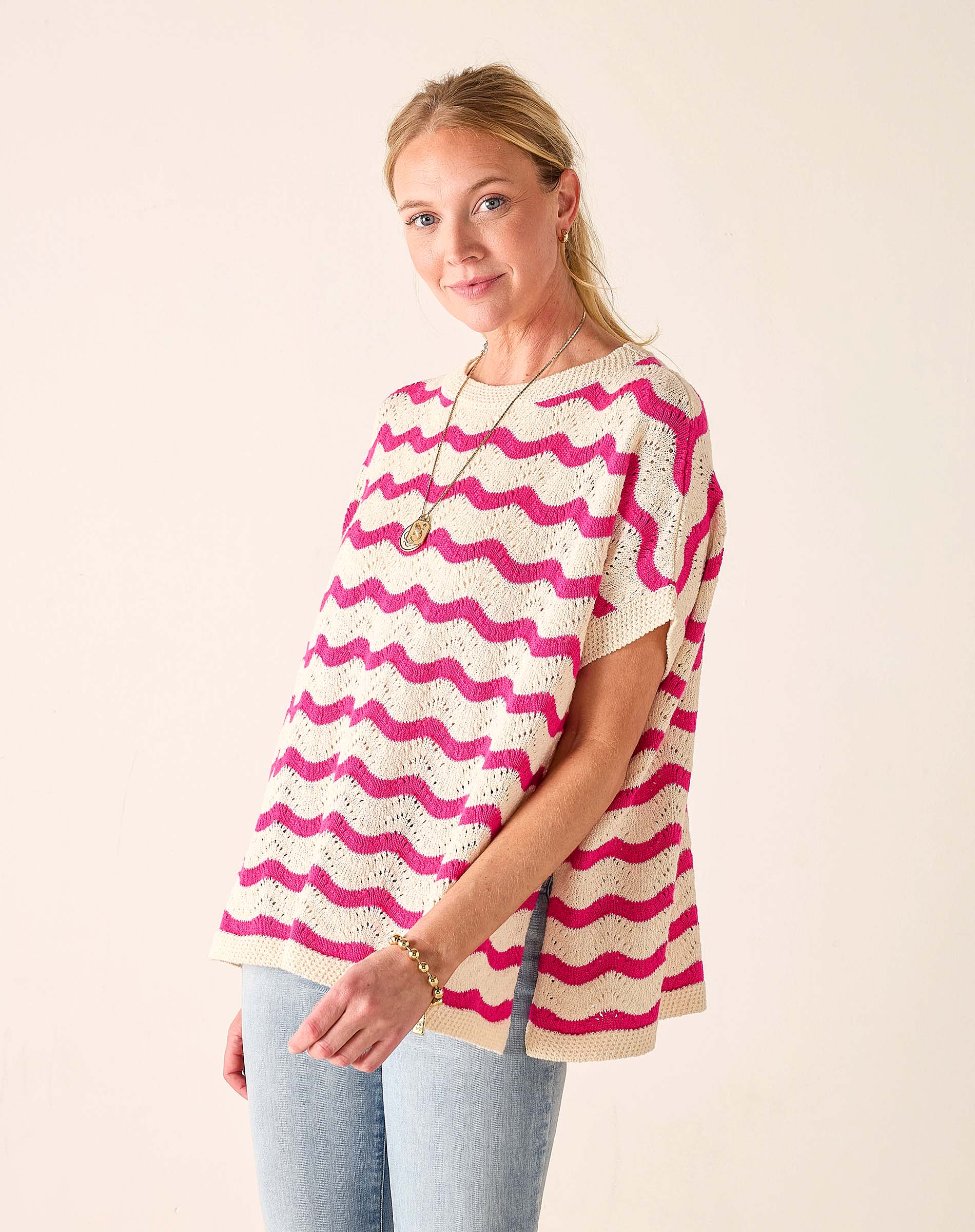 Woman wearing a pink and white patterned top against a plain background