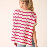 Woman wearing a pink and white striped poncho against a beige background