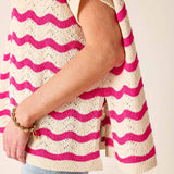 Person wearing a pink and white striped sweater with a plain background