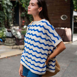 Woman wearing a blue and white striped poncho in an outdoor setting