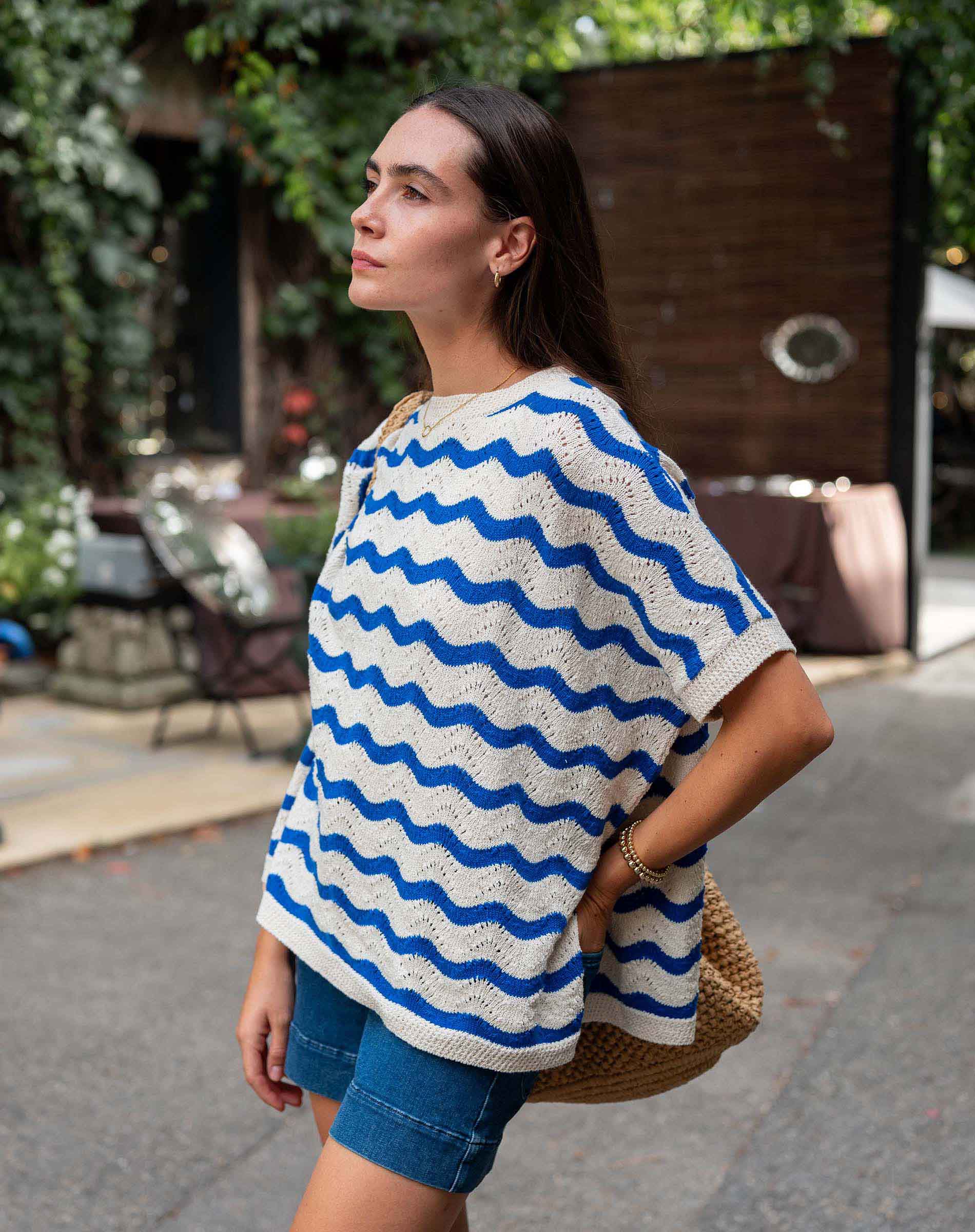 Woman wearing a blue and white striped poncho in an outdoor setting