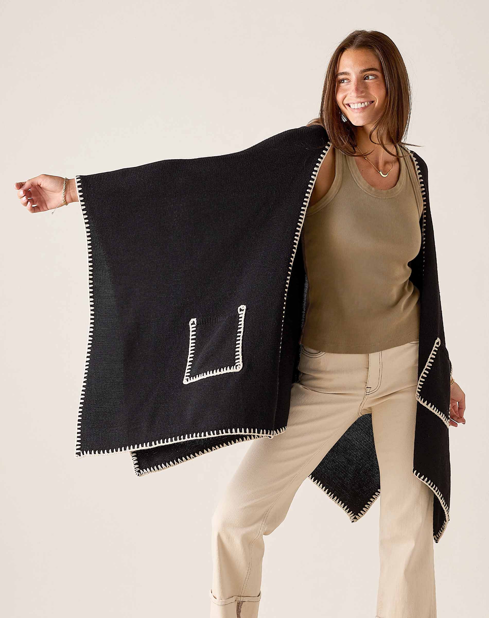 Black travel wrap with cream whipstitch trim and a stylized 'L' shape detail.