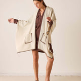 MERSEA women's travel-friendly cream and bronze whipstitch wrap with a large front pocket.