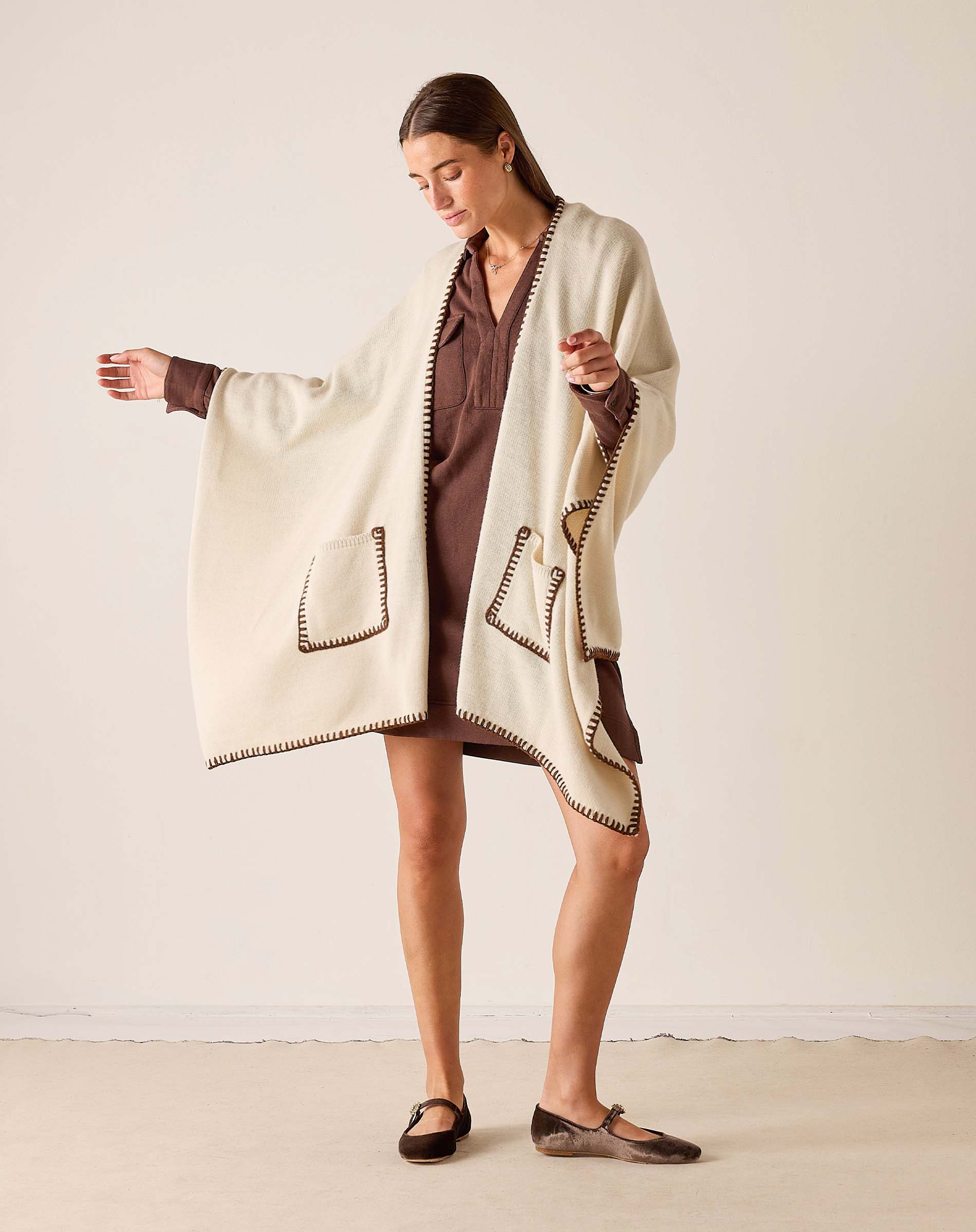 MERSEA women's travel-friendly cream and bronze whipstitch wrap with a large front pocket.