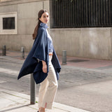 MERSEA women's travel-friendly women's travel-friendly navy whipstitch travel wrap over a knit top and high-waisted trousers.