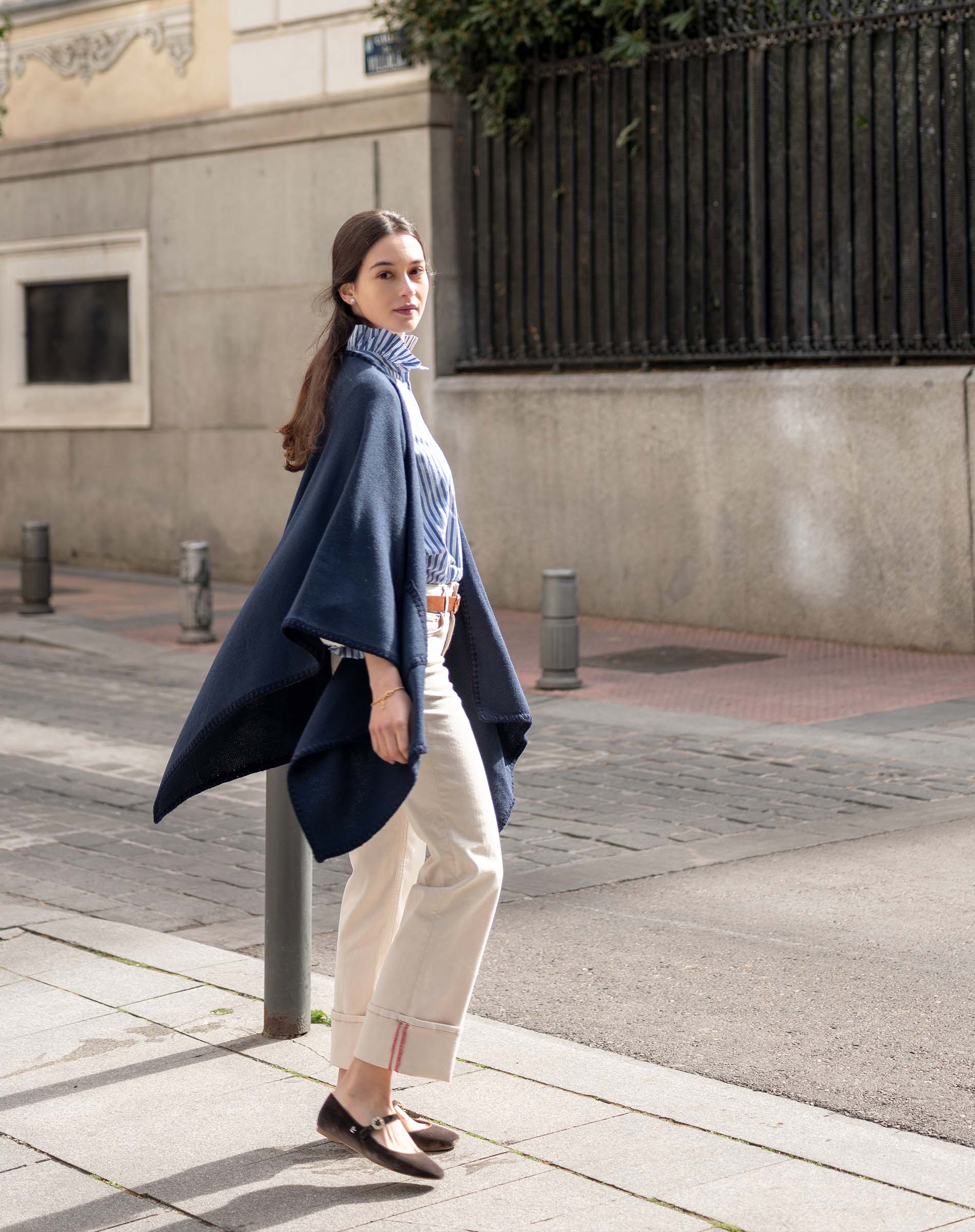 MERSEA women's travel-friendly women's travel-friendly navy whipstitch travel wrap over a knit top and high-waisted trousers.