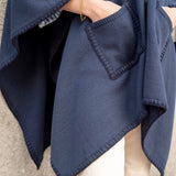 Detail of navy whipstitch travel wrap with large front pocket and visible seam stitching.