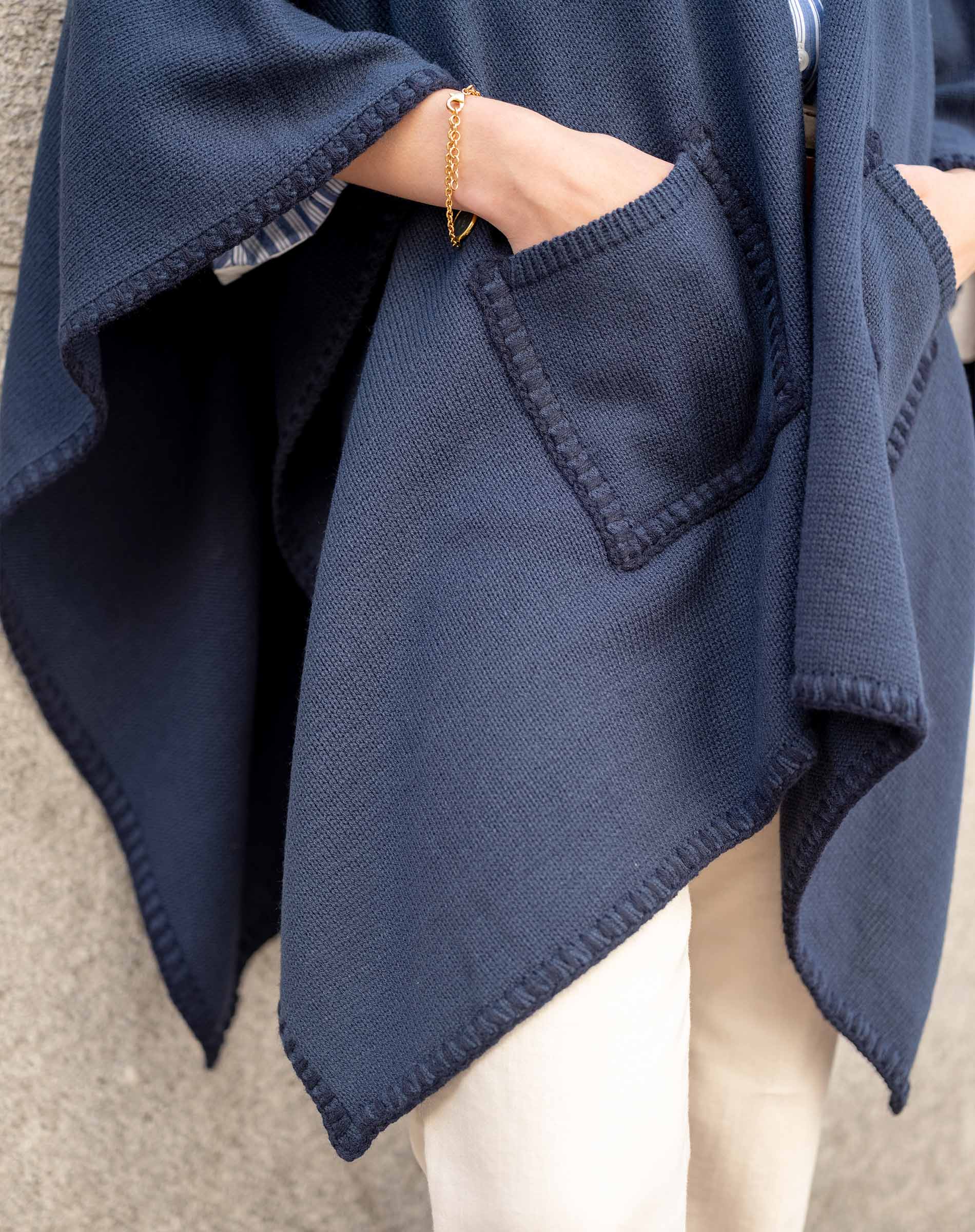 Detail of navy whipstitch travel wrap with large front pocket and visible seam stitching.