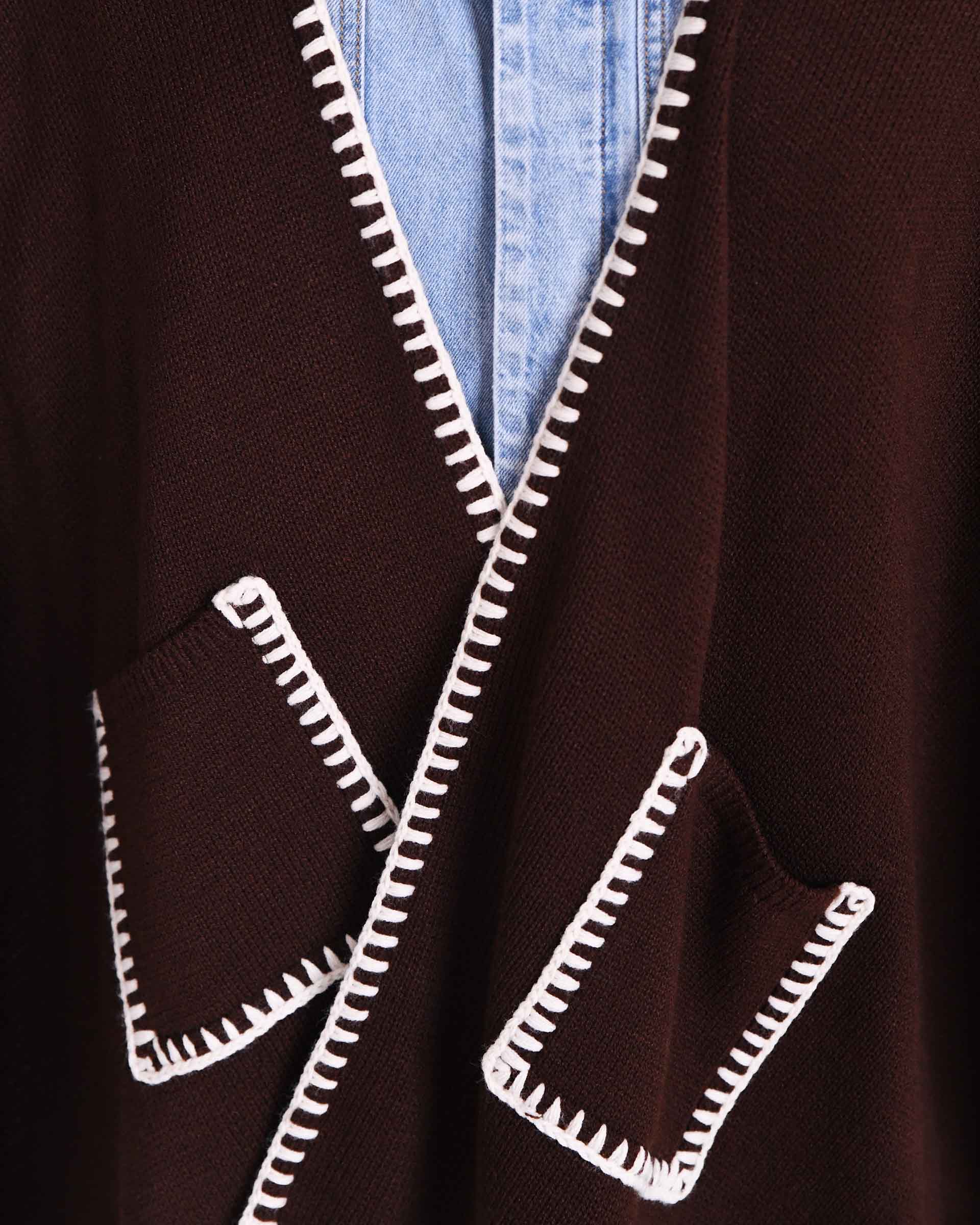 MERSEA ladies' travel-ready women's travel-friendly detail view of the chocolate brown knit wrap featuring a white whipstitch edge and front pockets.