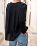Women's Black Front Pocket Pleated Back Crew Neck Long Sleeve Tee Rear View Travel Destination Hand in Back Pocket