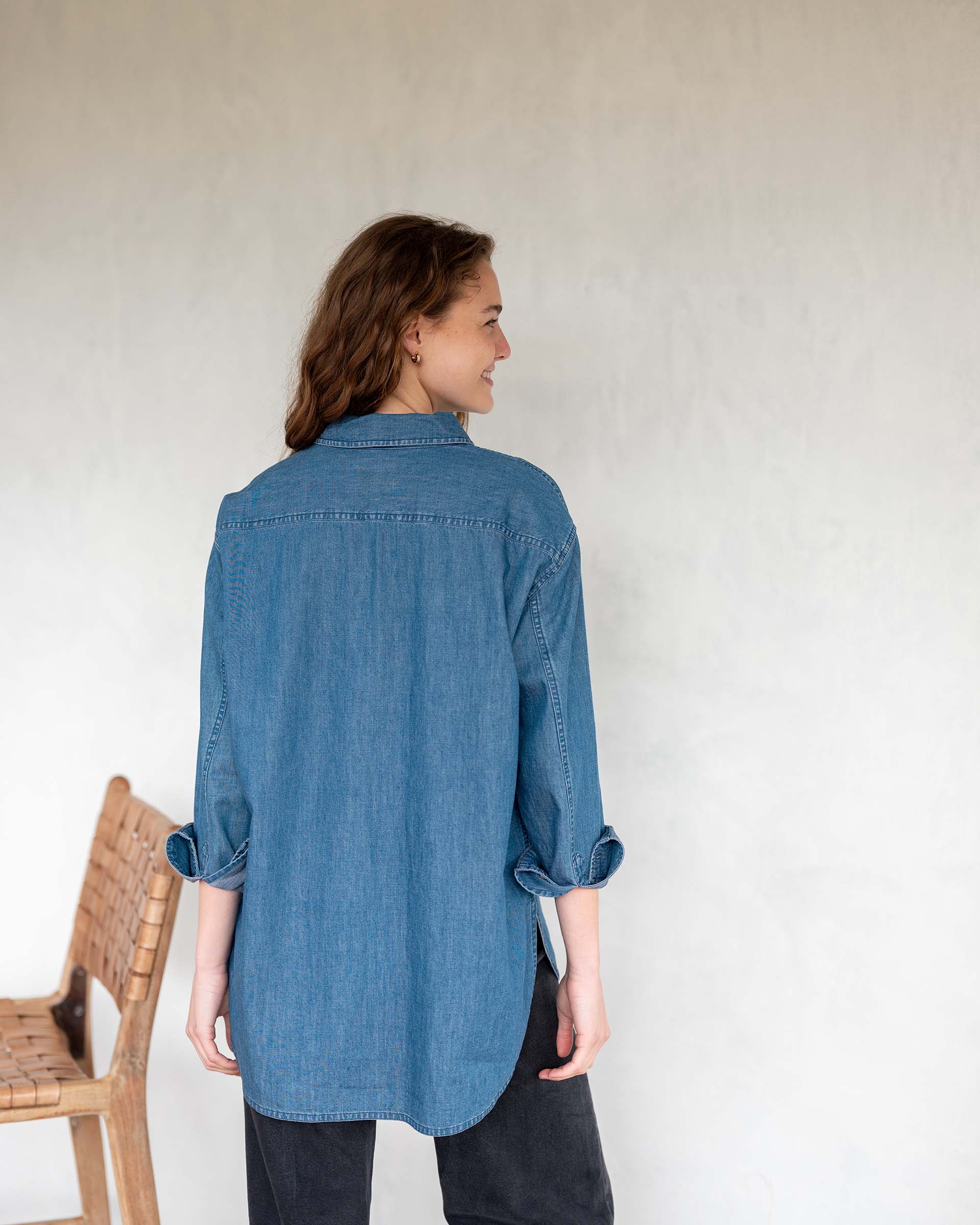 MERSEA ladies' travel-ready ladies' travel-ready back view of the blue chambray button-up top with oversized cuffs.