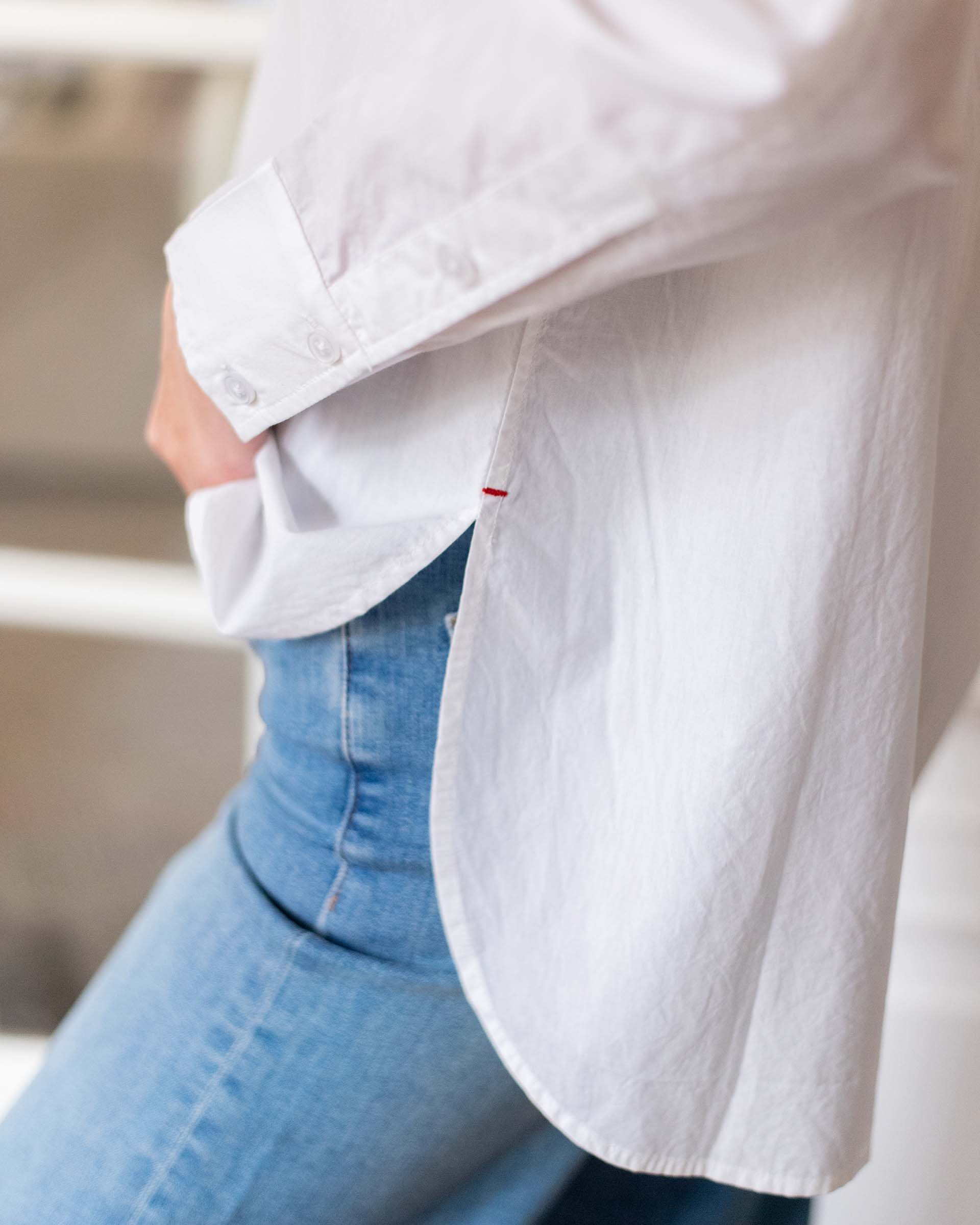 Women's White Breathable Relaxed Fit Button Up Shirt Side View close Up with Red Stitching Detail