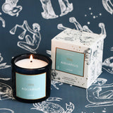 Candle and packaging with 'Aquarius' theme on a zodiac patterned background