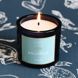 Candle labeled 'Aquarius' with a blue label on a dark blue background with zodiac signs.
