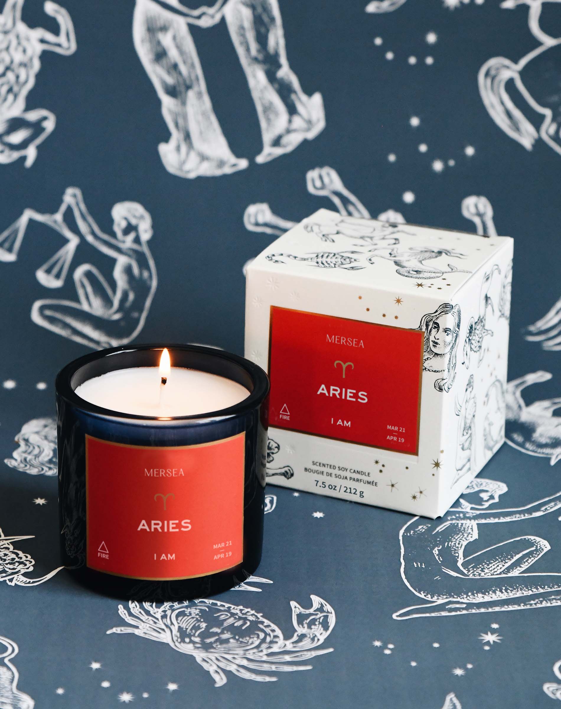 Aries candle and packaging on a zodiac-themed background
