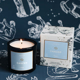 Candle and packaging with 'Cancer' design on a starry night background