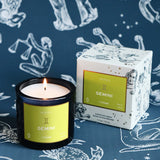 Candle and packaging with 'Gemini' label on a zodiac-themed background