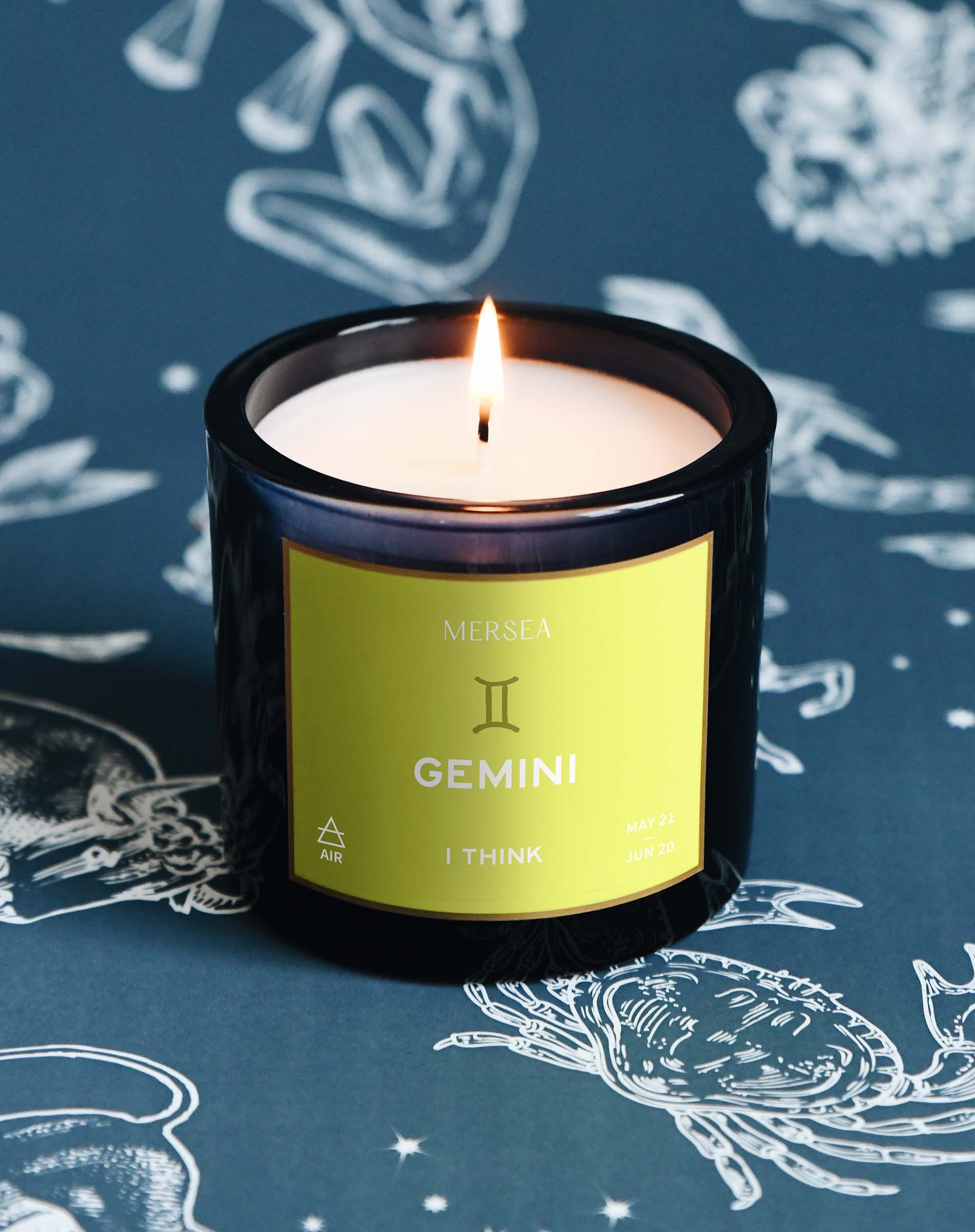 Candle labeled 'Gemini' by Mersea on a blue background with astrological designs