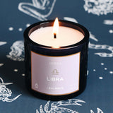 Candle labeled 'Libra' on a dark background with astrological designs