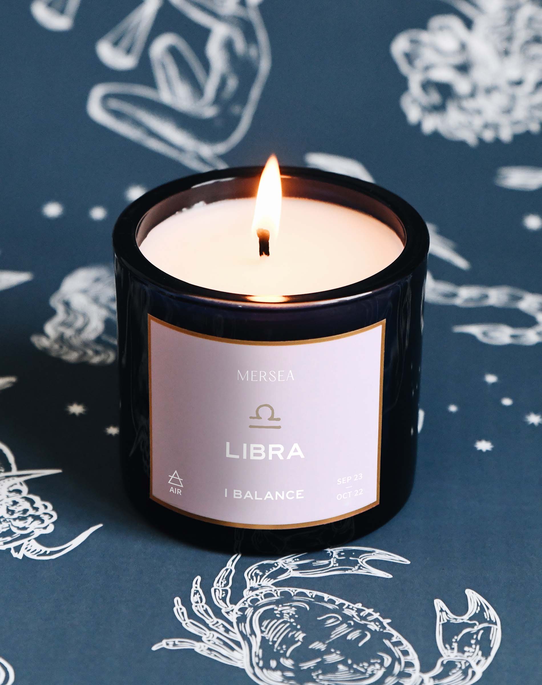 Candle labeled 'Libra' on a dark background with astrological designs
