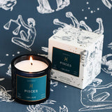 Pisces candle and packaging on a blue background with zodiac illustrations