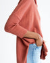 closeup of cuff on woman wearing mersea newport sweater in sienna color with a split front turtleneck and ribbed sleeves.